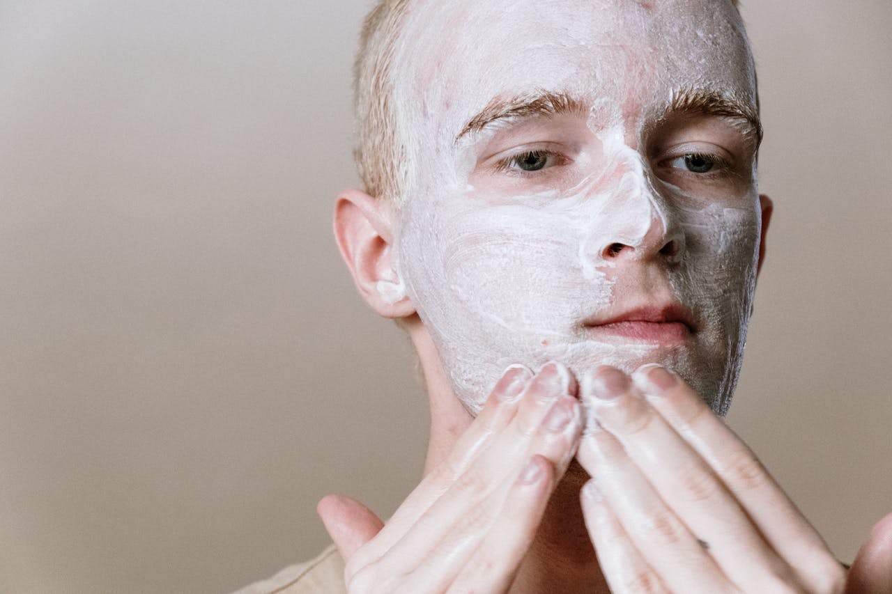 Close-up of a man applying facial cleanser for a refreshing skincare routine, focusing on self-care and health.